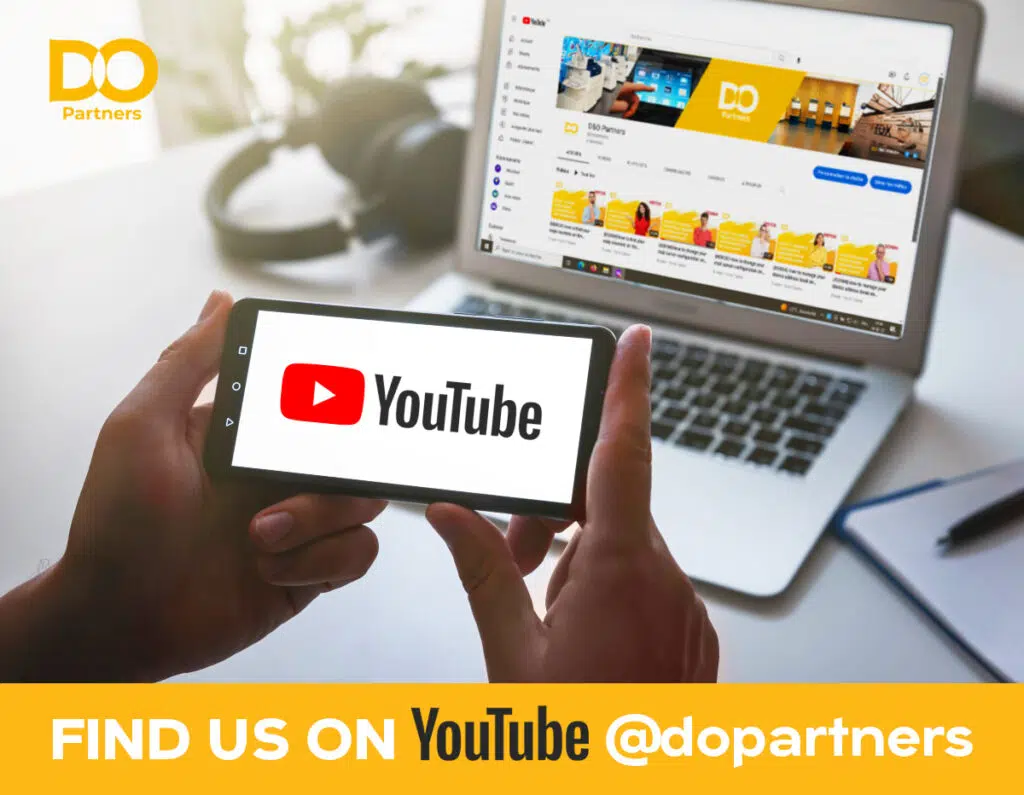 Deux mains tenant un smartphone affichant le logo de YouTube, au-dessus d'un ordinateur portable ouvert sur la chaîne YouTube de D&O Partners, accompagné du texte "FIND US ON YouTube @dopartners".