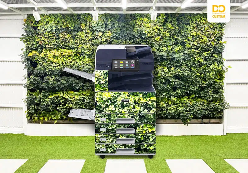 A Xerox copier customised to blend in with the greenery of an office, illustrating D&O Partners' made-to-measure customisation service.