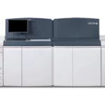 Xerox Nuvera perfecting production system, een high-performance zwart-wit publicatieprinter. De machine, met zijn kenmerkende donkerblauwe en witte kleurstelling, is voorzien van een monitor op het bovenpaneel en biedt gestroomlijnde, efficiënte afdrukmogelijkheden voor professionele printomgevingen die zich richten op kwalitatief hoogwaardige monochrome publicaties.