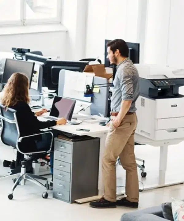 Employés de bureau travaillant à côté d’une imprimante multifonction Xerox VersaLink B625 dans un environnement de travail moderne.