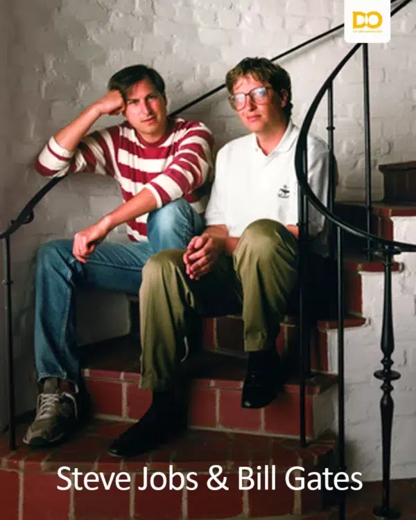 Steve Jobs and Bill Gates sitting together on a staircase