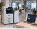 Xerox A3 multifunction printer in an office environment, connected to a Managed Print Services dashboard for centralized print fleet management.